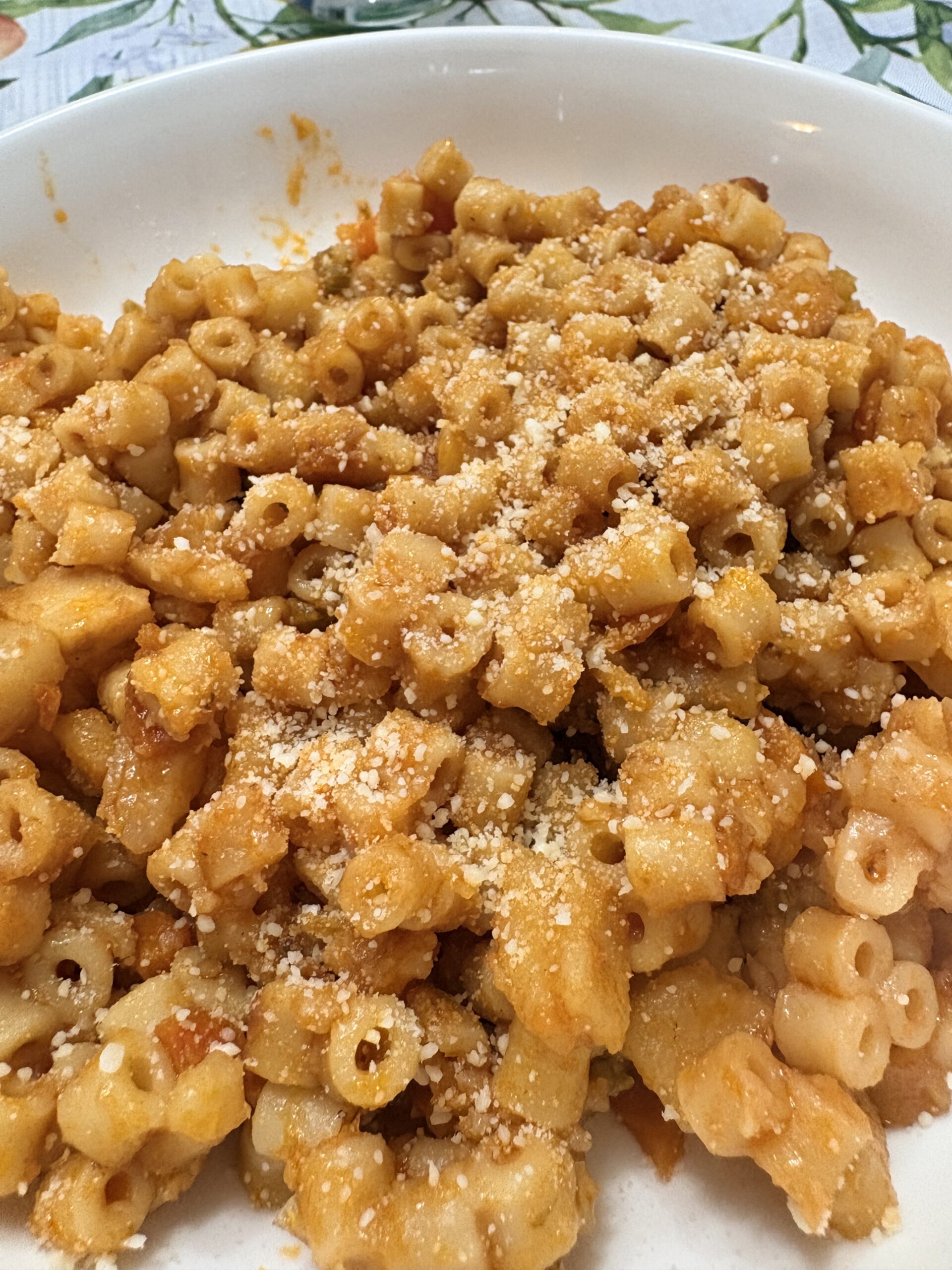 Small pasta and potatoes in a golden-orange sauce with grated Parmesan